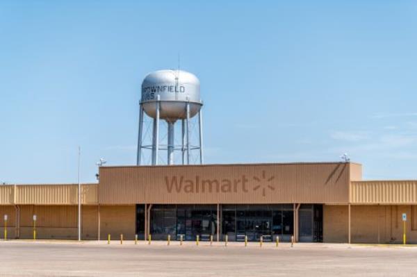 Texas countryside industrial town with old vintage run-down Walmart and water tank with sign